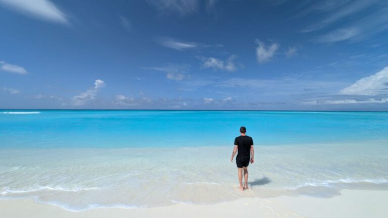 Dave stands in the sea on the beach admiring the turquoise ocean of fulhadhoo
