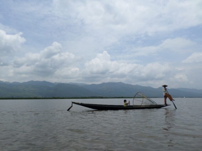 Fisherman on Inle Lake uses his foot with the padel to propel himself